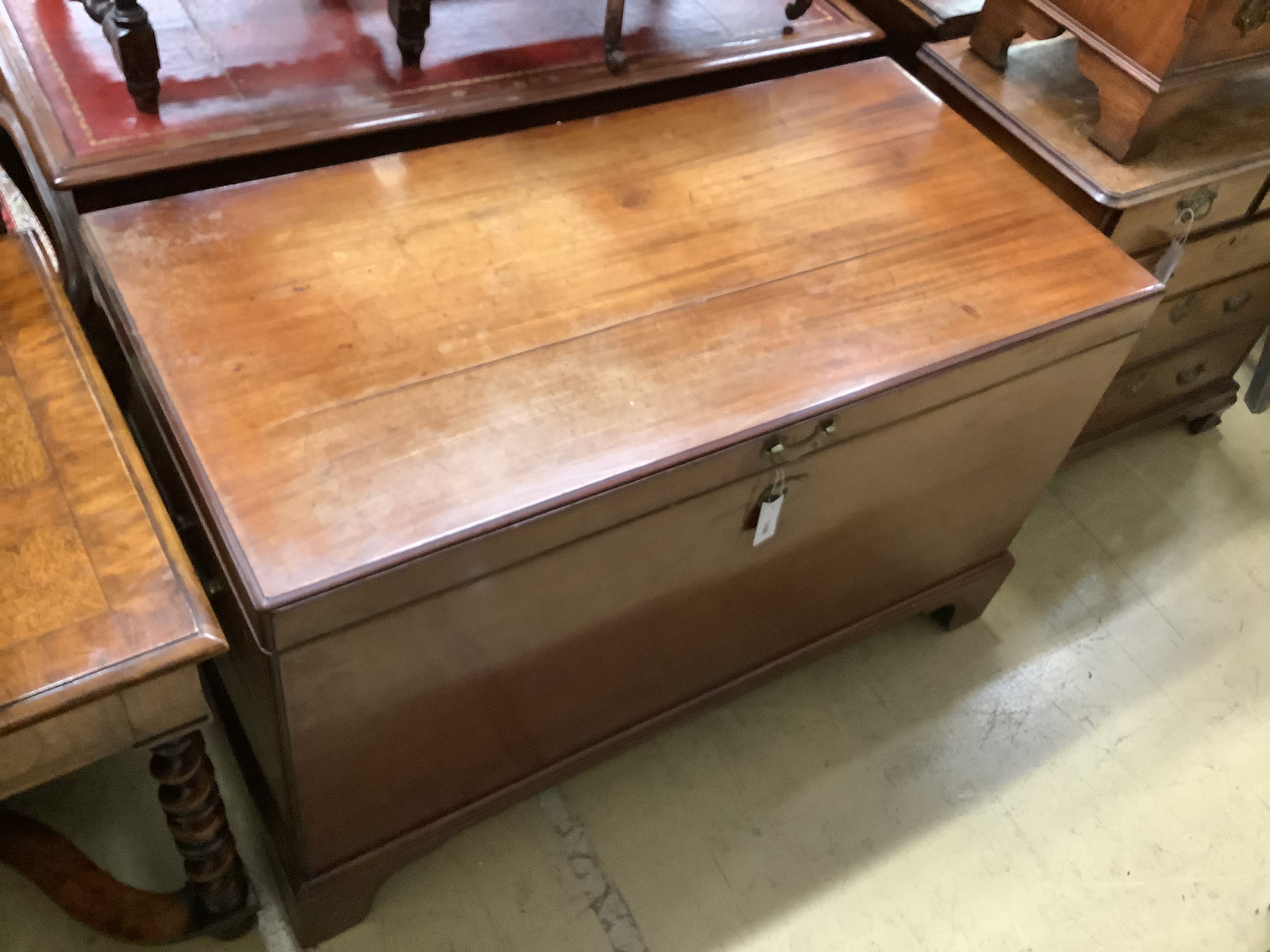 A George III mahogany coffer, with brass loop handles, on bracket feet (cracked), length 122cm, depth 60cm, height 76cm